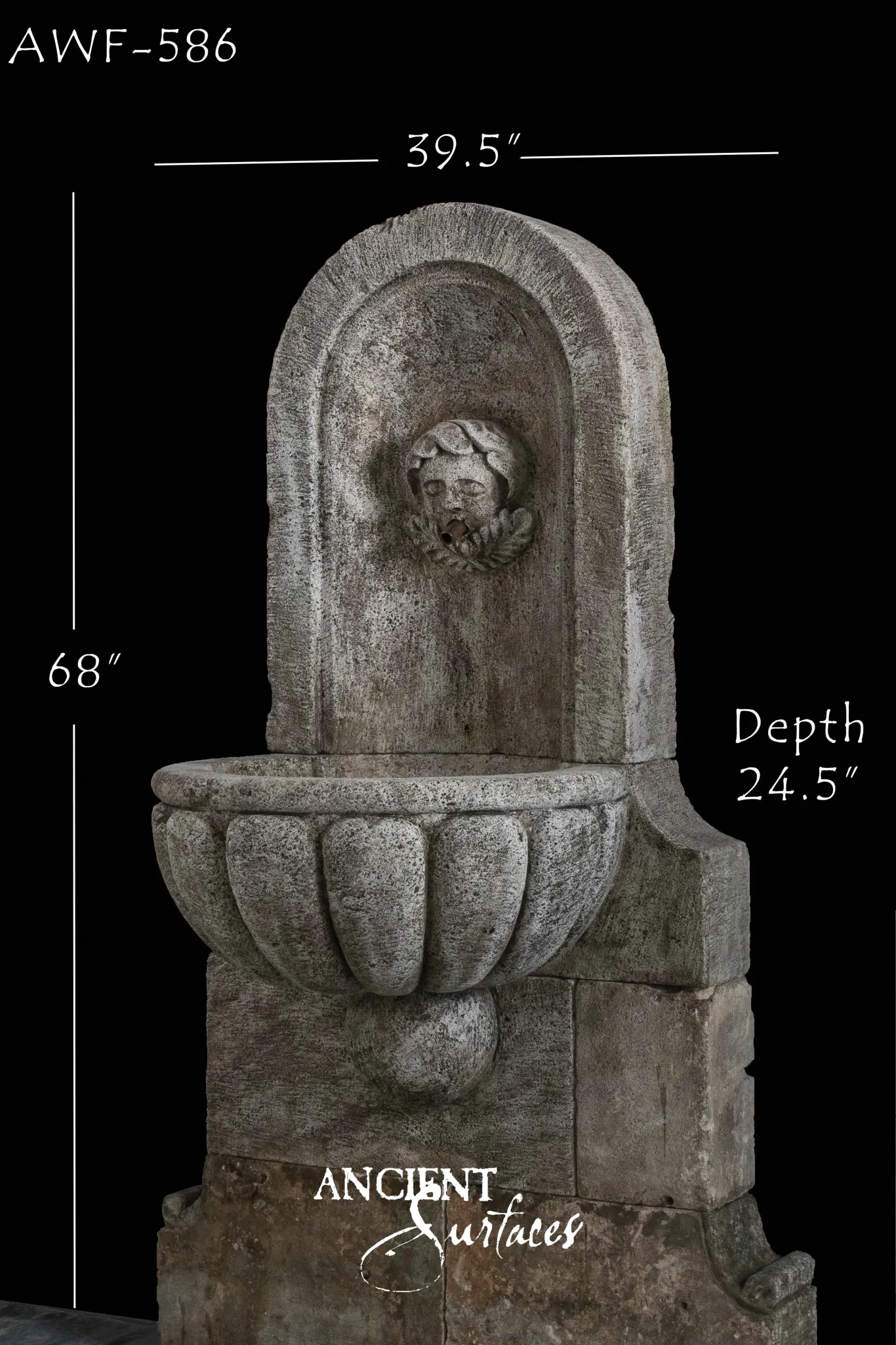 Reclaimed antique limestone wall fountain from Ancient Surfaces with a cherub mask in an arched niche above a lobed stone bowl