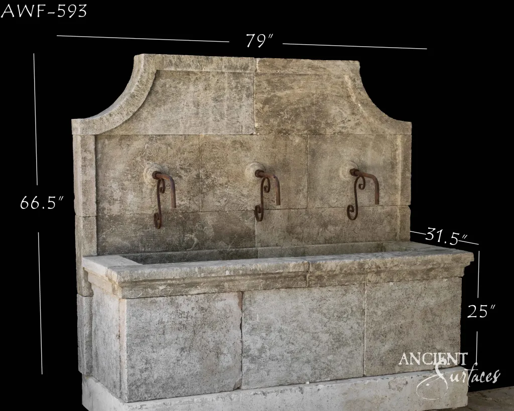 Ancient Surfaces reclaimed antique limestone wall fountain with three forged iron spouts above a long stone trough