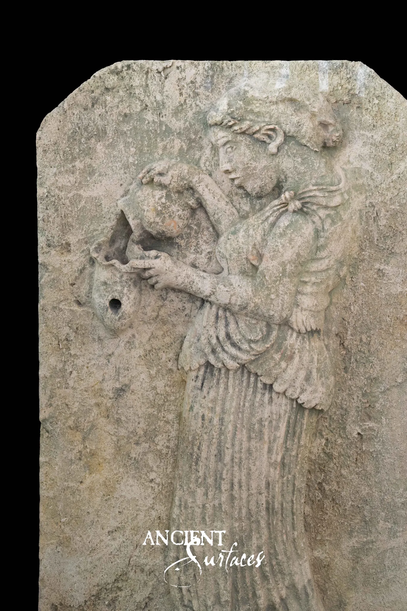 Reclaimed antique limestone fountain panel from Ancient Surfaces carved in relief with a robed water bearer pouring from an amphora